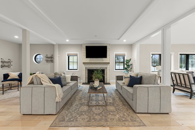 living room with a fireplace and light wood-type flooring