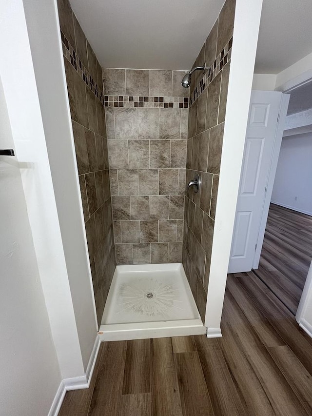 bathroom featuring a tile shower and hardwood / wood-style floors