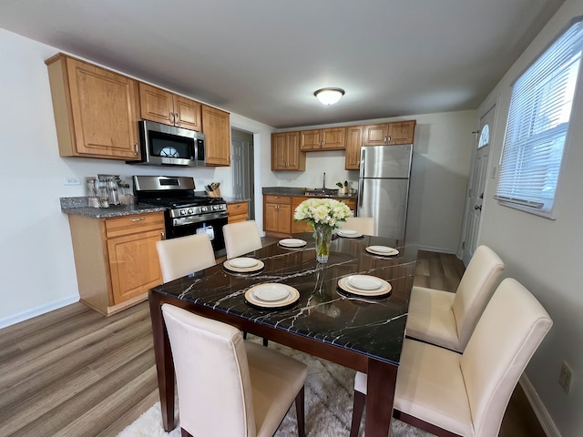 kitchen with stainless steel appliances, light hardwood / wood-style flooring, and sink