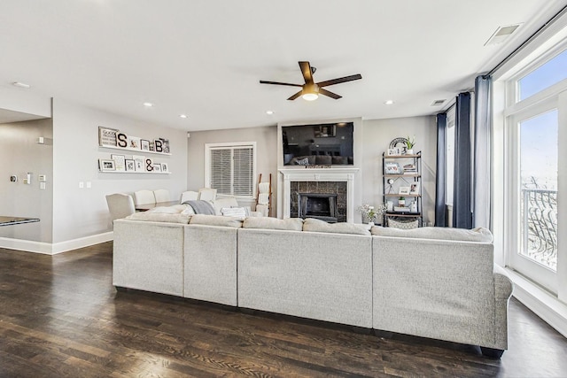 living room with a tile fireplace, ceiling fan, and dark hardwood / wood-style floors