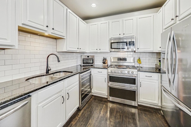 kitchen with stainless steel appliances, beverage cooler, and white cabinetry