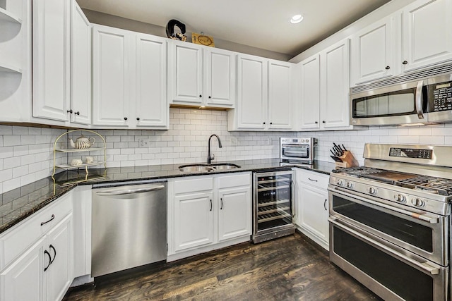 kitchen featuring sink, white cabinets, beverage cooler, and appliances with stainless steel finishes