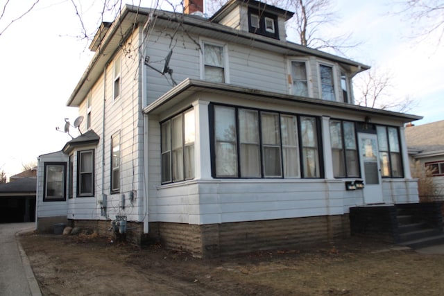 view of side of home with a sunroom