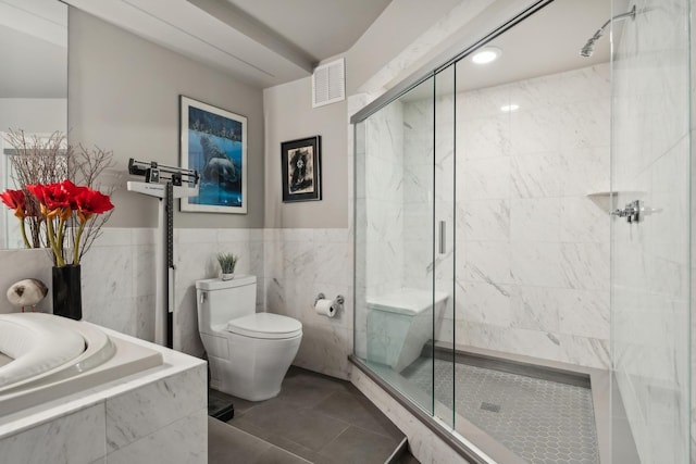 bathroom with tile patterned flooring, toilet, and walk in shower