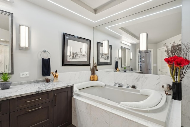 bathroom with vanity and a relaxing tiled tub