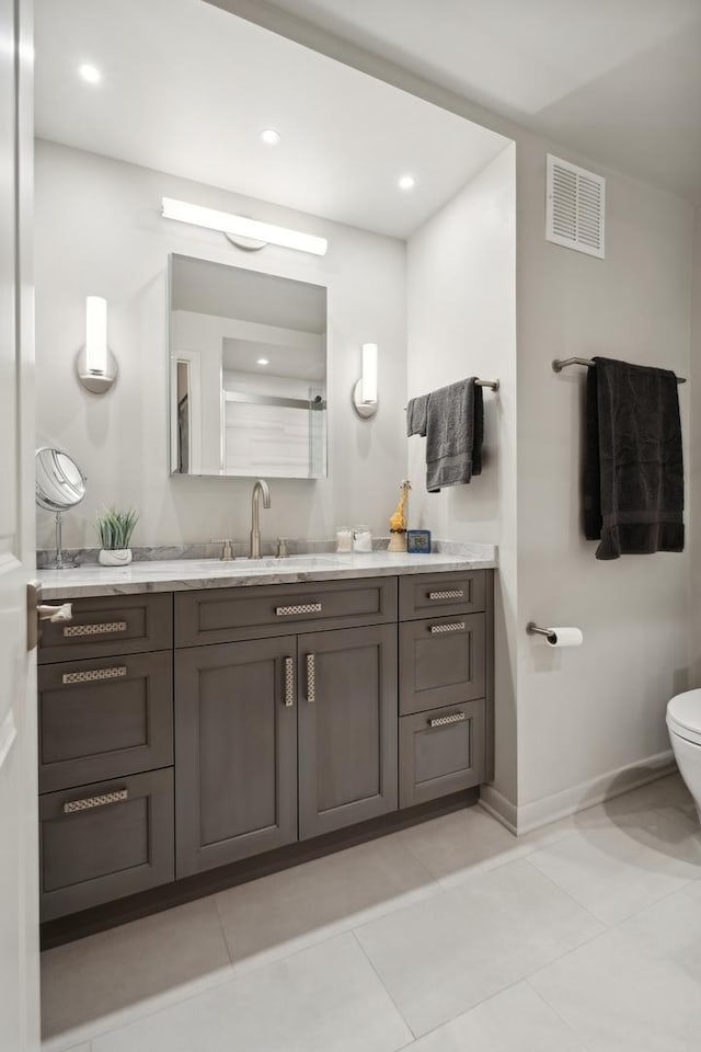 bathroom featuring tile patterned floors, vanity, and toilet