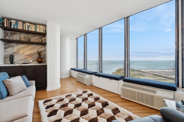 living room with a water view and light hardwood / wood-style flooring