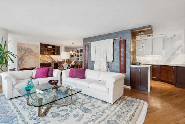 living room with light hardwood / wood-style flooring and a notable chandelier