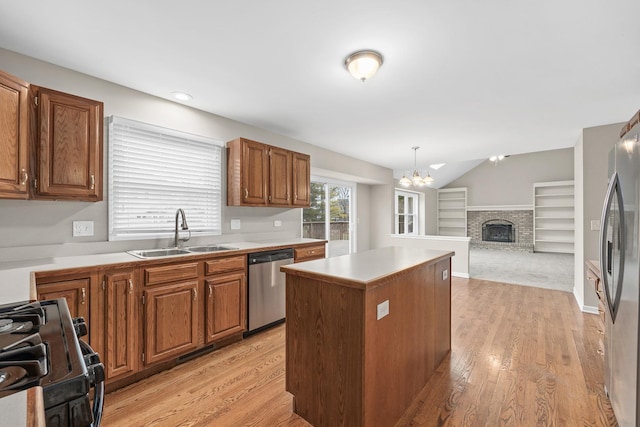 kitchen with a center island, hanging light fixtures, sink, appliances with stainless steel finishes, and a chandelier