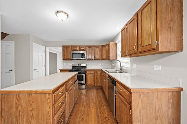 kitchen with hardwood / wood-style flooring, sink, a center island, and appliances with stainless steel finishes