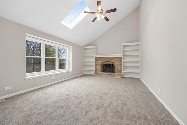 unfurnished living room with carpet, high vaulted ceiling, a skylight, ceiling fan, and a fireplace