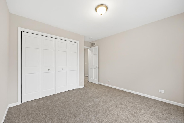 unfurnished bedroom with carpet flooring and a closet