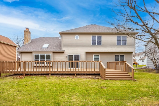 rear view of house featuring a lawn and a wooden deck