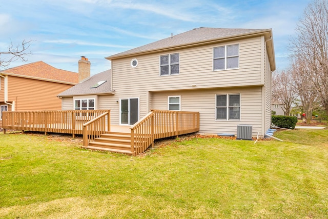 rear view of property with a yard, central AC, and a deck