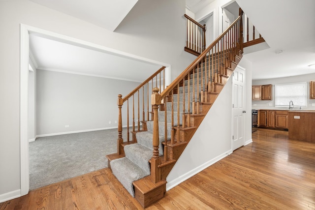 staircase featuring hardwood / wood-style floors and ornamental molding