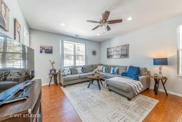 living room with wood-type flooring and ceiling fan