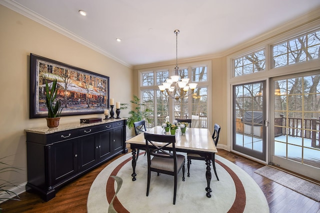 dining space with ornamental molding, dark wood-type flooring, and an inviting chandelier