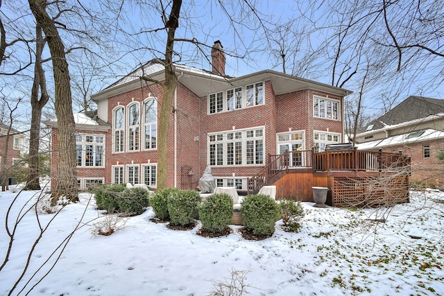 snow covered house with a wooden deck