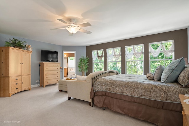 bedroom featuring ensuite bath, ceiling fan, and light carpet