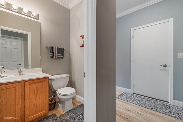 bathroom with hardwood / wood-style floors, vanity, toilet, and crown molding