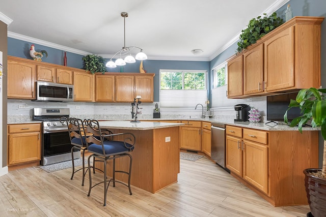 kitchen with a center island, light stone counters, light wood-type flooring, and stainless steel appliances