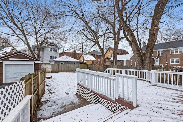 snow covered deck with a garage and an outdoor structure