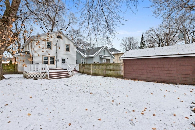 snow covered house with a deck