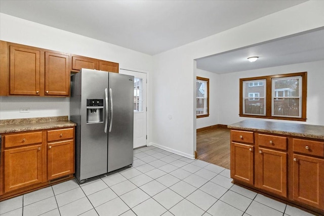 kitchen featuring stainless steel fridge with ice dispenser and light tile patterned floors