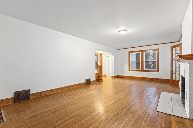 unfurnished living room with a fireplace, hardwood / wood-style floors, and ornamental molding