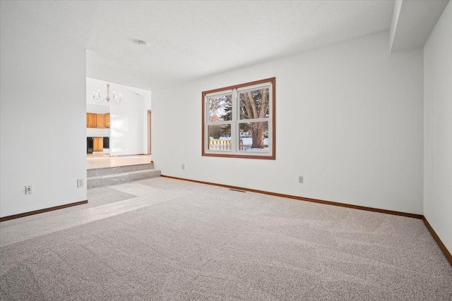 empty room featuring a chandelier and light carpet