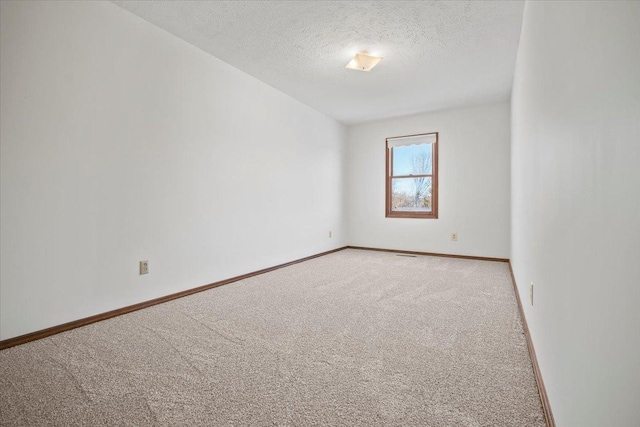 carpeted spare room with a textured ceiling