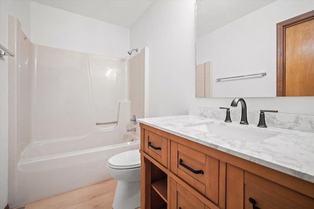 full bathroom featuring toilet, hardwood / wood-style floors, bathing tub / shower combination, and vanity