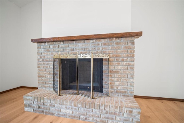 room details with hardwood / wood-style floors and a brick fireplace