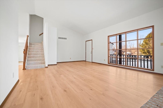 unfurnished living room with light hardwood / wood-style floors and lofted ceiling