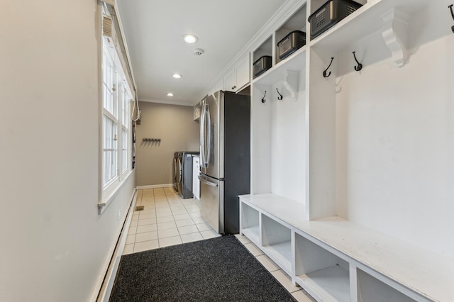 mudroom with light tile patterned flooring, independent washer and dryer, and crown molding