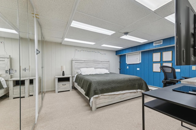 carpeted bedroom with a paneled ceiling