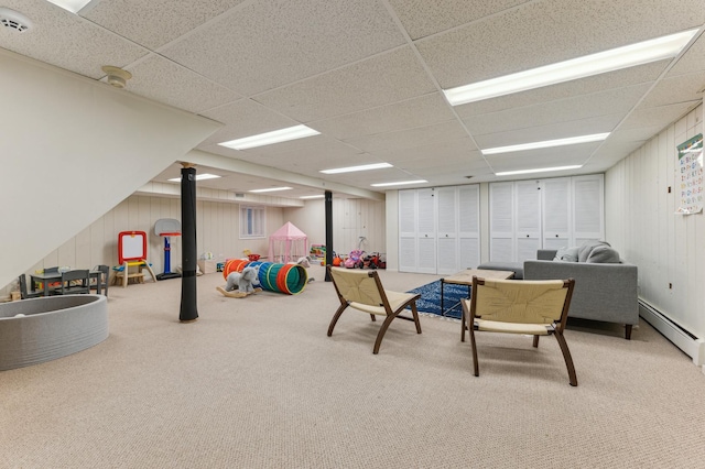 interior space featuring baseboard heating, carpet floors, and a drop ceiling