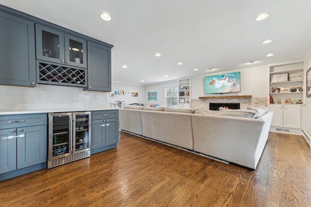 unfurnished living room with ornamental molding, dark wood-type flooring, bar area, and beverage cooler