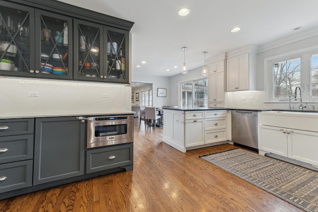 kitchen with white cabinetry, pendant lighting, stainless steel appliances, and kitchen peninsula