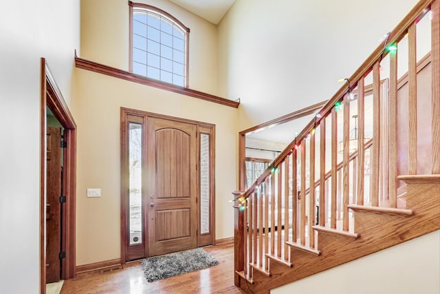 foyer with a towering ceiling and light hardwood / wood-style floors