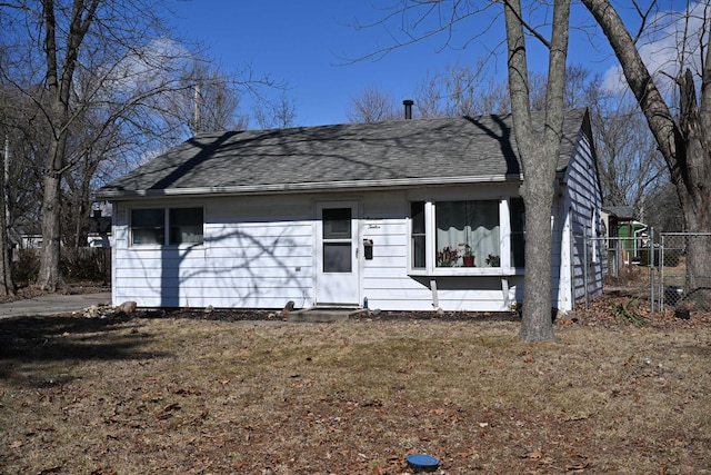 view of front of house with a shingled roof and fence