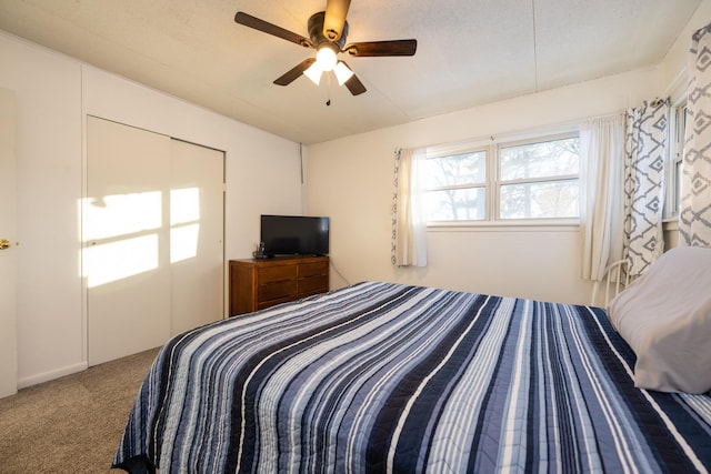 carpeted bedroom featuring a ceiling fan and a textured ceiling