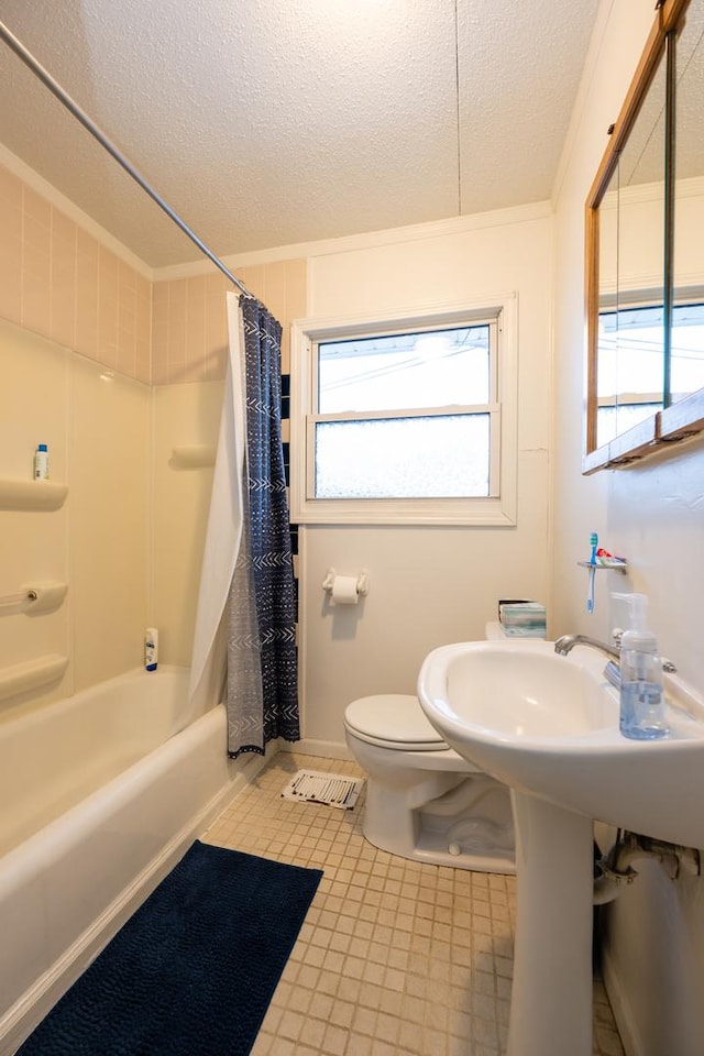 bathroom with a textured ceiling, toilet, and shower / bath combo with shower curtain