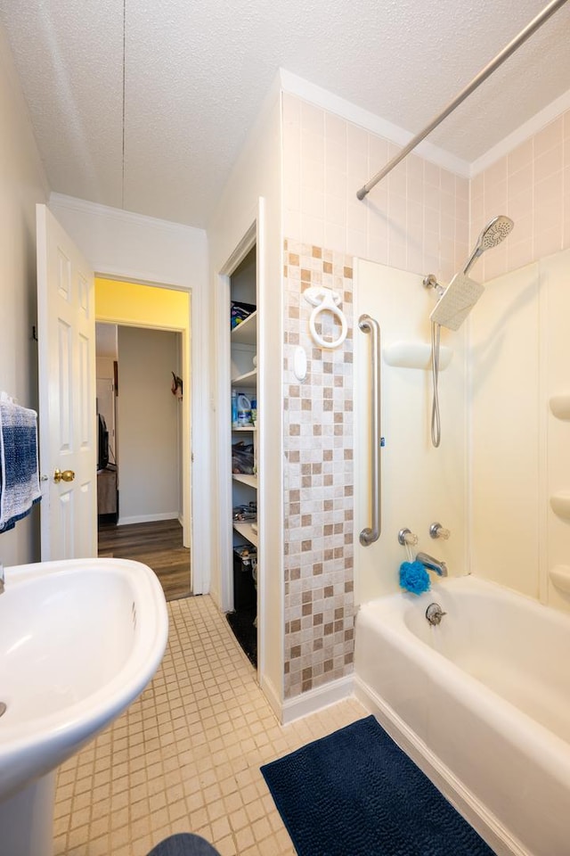 bathroom featuring tile patterned floors, a walk in closet, a textured ceiling, and shower / bathtub combination