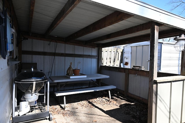 view of patio with a carport, a shed, area for grilling, and an outdoor structure