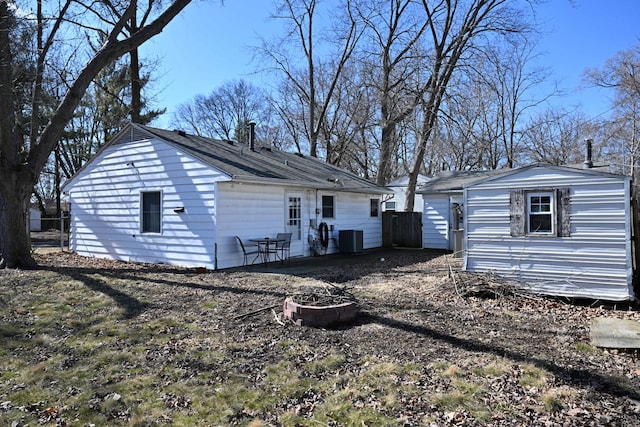 view of home's exterior featuring central air condition unit, fence, and an outbuilding