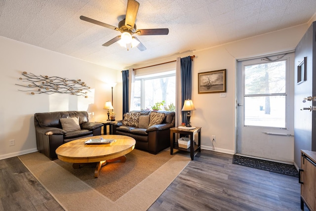 living area featuring wood finished floors, a ceiling fan, and baseboards