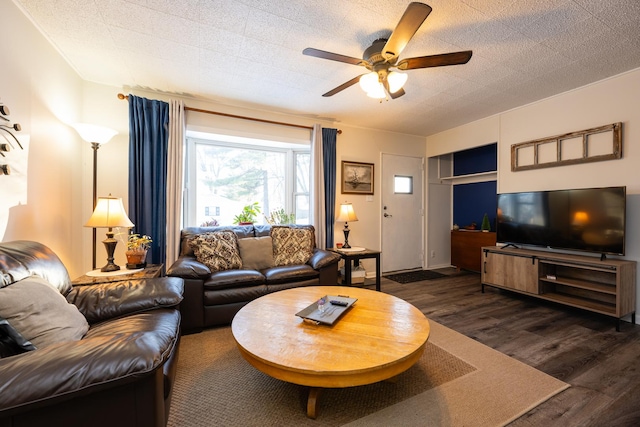 living area with ceiling fan, a textured ceiling, and wood finished floors