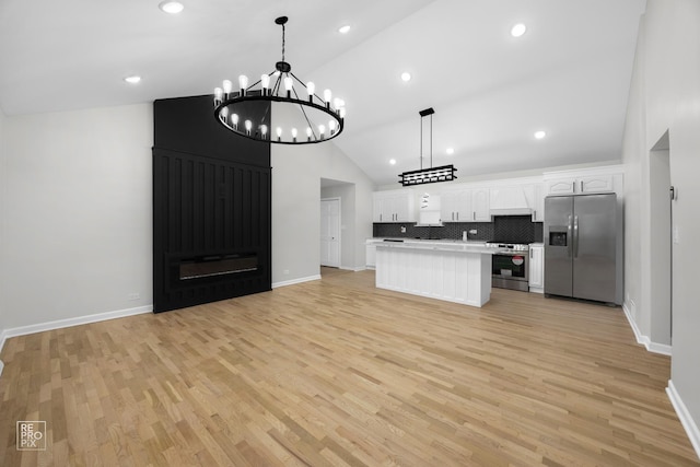 kitchen featuring appliances with stainless steel finishes, a center island, white cabinetry, and pendant lighting