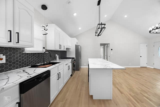 kitchen with a center island, sink, stainless steel appliances, decorative light fixtures, and white cabinets